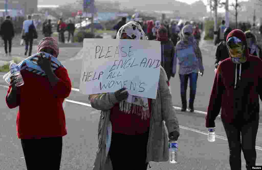 Para migran berdemonstrasi melawan pembongkaran kamp migran &quot;The Jungle&quot; di Calais, Perancis (25/10). (Reuters/Philippe Wojazer)