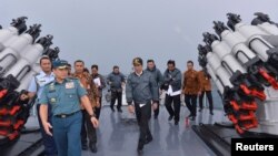 Presiden Joko Widodo di atas dek kapal Angkatan Laut KRI Imam Bonjol dengan beberapa anggota kabinet di perairan Kepulauan Natuna, Riau (23/6). 