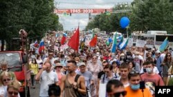 People hold banners and signs during an unauthorised rally in support of Sergei Furgal, the governor of the Khabarovsk region who was arrested, in the Russian far eastern city of Khabarovsk on July 25, 2020.
