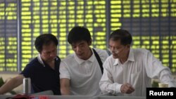 Investors talk at a brokerage house in Nantong, Jiangsu province, China, July 3, 2015. China's stock markets have had been decreasing since June.