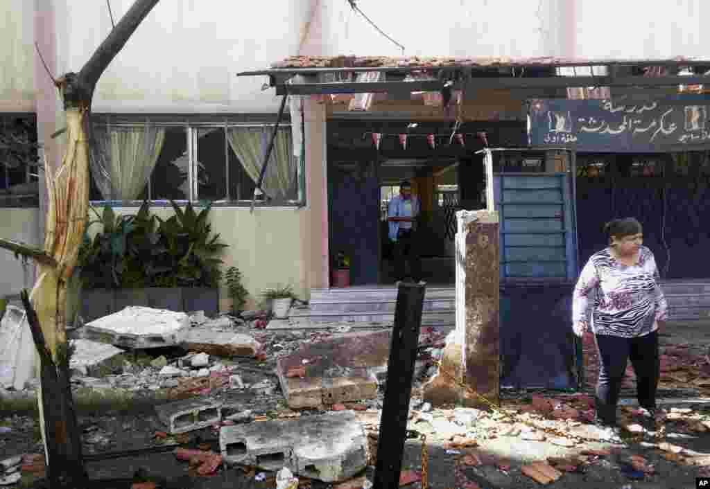 Syrian citizens check the damaged school entrance in Akrama neighborhood in Homs province, Syria, Oct. 1, 2014. 