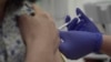 Screen grab taken from video issued by Oxford University, showing a person being injected as part of the first human trials in the UK to test a potential coronavirus vaccine, undertaken in England, April 23, 2020. 