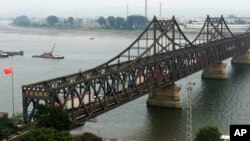 Trucks crosses the friendship bridge connecting China and North Korea in the Chinese border town of Dandong, opposite side of the North Korean town of Sinuiju, Monday, Sept. 4, 2017.