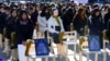 People sit around a statue of a "comfort woman" during an installation of empty chairs during a performance event, commemorating the death of eight former sex slaves this year, in Seoul, South Korea.