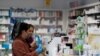 Women buy a hand sanitizer at a pharmacy in Milan, Italy, Feb. 26, 2020.