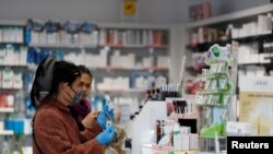 Women buy a hand sanitizer at a pharmacy in Milan, Italy, Feb. 26, 2020.