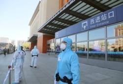 FILE - Policemen cordon off a railway station in Jilin city in northeast China's Jilin province, May 13, 2020. The city went into lockdown after a cluster of coronavirus cases broke out.