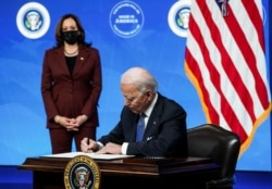 Momento en que el presidente Joe Biden, acompañado por la vicepresidenta Kamala Harris, firma la orden ejeccutiva 'Buy American' el 25 de enero de 2021.