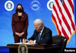 조 바이든(오른쪽) 미국 대통령이 지난해 1월 백악관에서 카멀라 해리스 부통령이 지켜보는 가운데 미국산 조달 확대 행정명령에 서명하고 있다. (자료사진)
