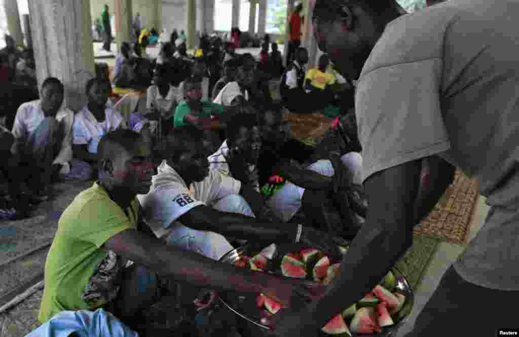 A man distributes watermelons to others as they break fast during the Islamic holy month of Ramadan at Nasfat Mosque in Utako, Abuja.