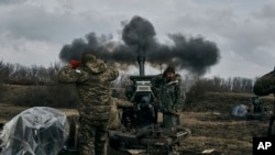 Soldados ucranianos disparan una pieza de artillería contra posiciones rusas cerca de Bájmut, en el este de Ucrania, el 7 de marzo de 2023.