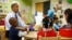 U.S. President Barack Obama reads a card during a game with children in a per-kindergarten classroom at College Heights early childhood learning center in Decatur, Georgia, February 14, 2013. 