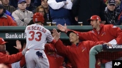 Daniel Descalso, de los Cardenales de San Luis, es felicitado por sus compañeros luego de anotar durante el séptimo inning del segundo juego de la Serie Mundial.