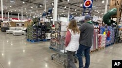 ARCHIVO - Compradores revisan los productos en un almacén de Costco el domingo 25 de febrero de 2024 en Sheridan, Colorado.