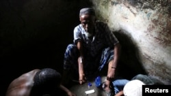 FILE - A heroin addict injects heroin in Lamu, Kenya, Nov. 21, 2014.