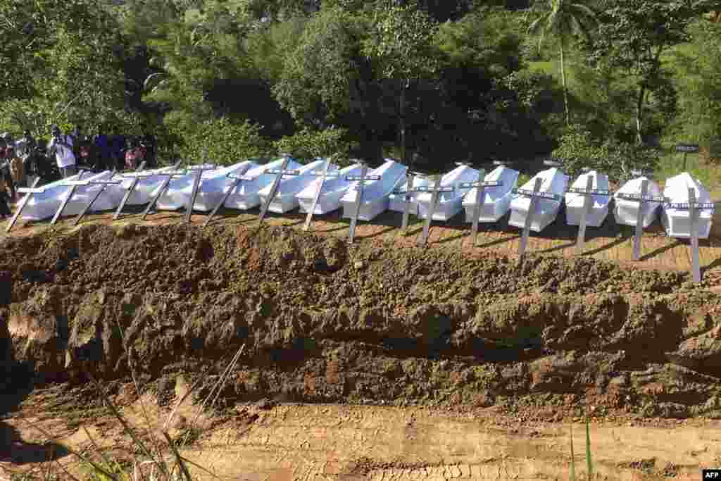 Caskets containing the remains of unidentified flood victims are prepared for burial in a mass grave in Sentani, Indonesia.