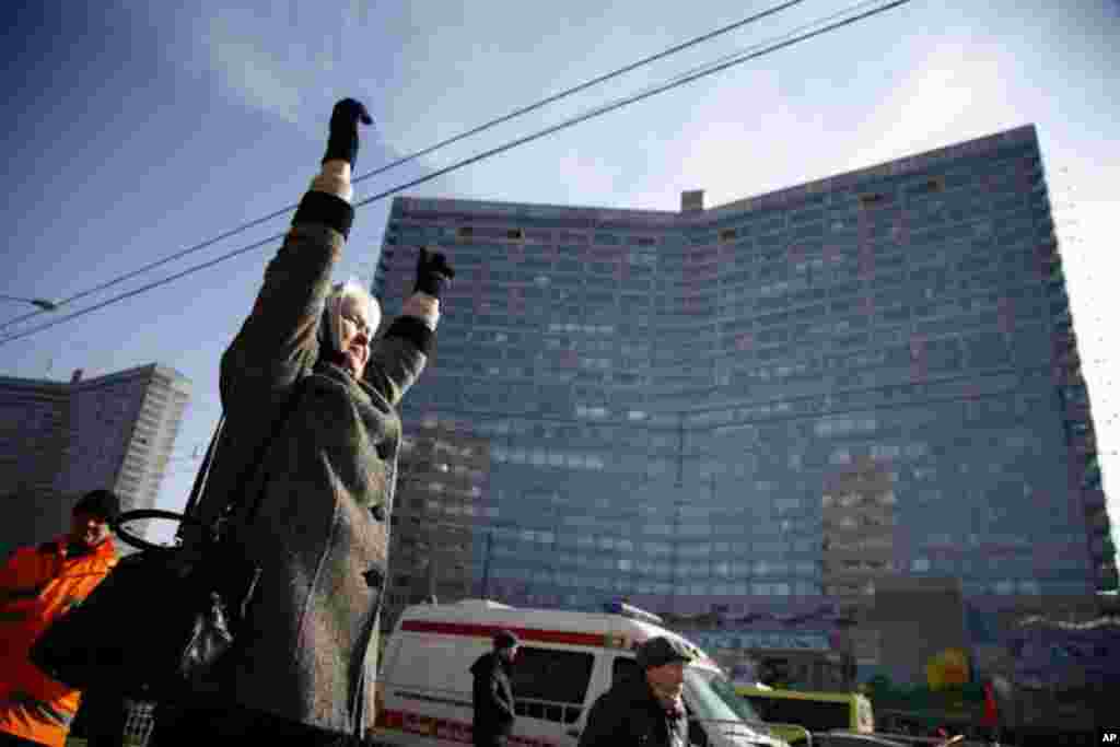 An woman cheers from the across the street at a rally for fair elections in Moscow. (VOA Photo - Yuli Weeks)