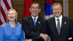 아세안지역 안보포럼(ARF)에 참석한 클린턴(좌) 미 국무장관과 마쓰모토 다케아키 일본 외무상(사진 중앙) 김성환(우) 한국 외교통상부 장관이 인도네시아 발리 국제회의장에서 3자 외교장관 회의를 갖기에 앞서 손을 맞잡고 기념촬영을 하고 있다.