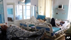 Warga Afghanistan berbaring di tempat tidur di sebuah rumah sakit setelah mereka terluka dalam serangan mematikan di luar bandara di Kabul, Afghanistan, Jumat, 27 Agustus 2021. (Foto: AP)
