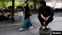 FILE - A Uighur man looks at a passing Han woman outside of his restaurant in Shanghai, April 23, 2014. 