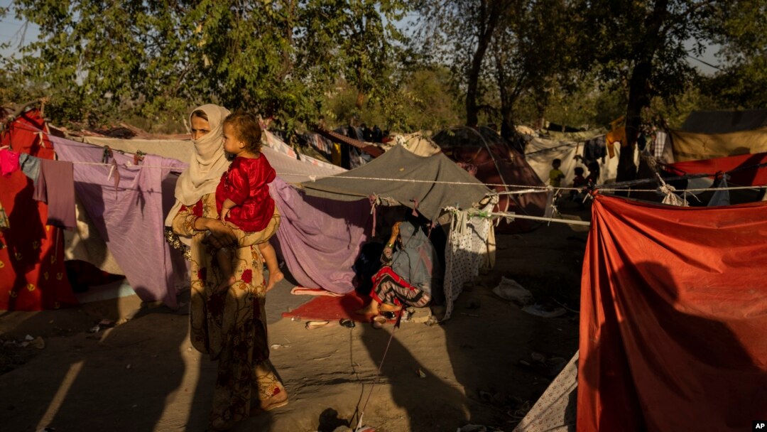 FILE - An internally displaced woman holds a child at an displaced persons camp in Kabul, Afghanistan, Sept. 13, 2021.