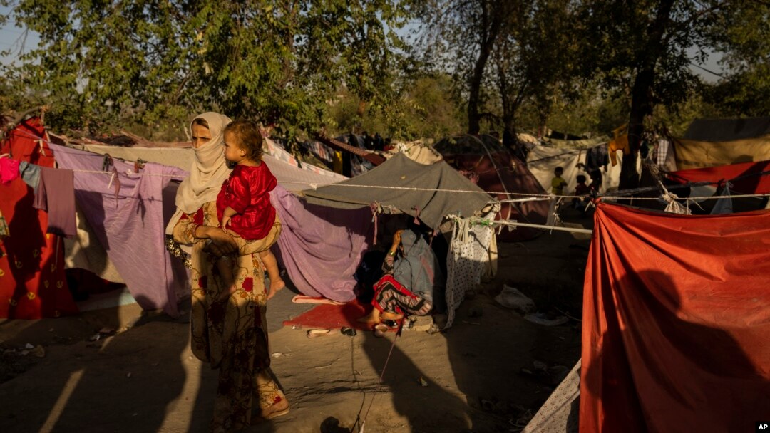 Seorang perempuan pengungsi menggendong seorang anak di sebuah kamp pengungsi di Kabul, Afghanistan, 13 September 2021. (Foto: AP)