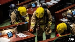 تیم آتش‌نشانی در حال انجام آزمایش در مجلس قانونگذاری هنگ کنگ است. قانونگذاران دموکراسی‌خواه به دنبال سومین بار قرائت قانون سرود ملی در مجلس یک مایع بودار پاشیدند. ۴ ژوئن ۲۰۲۰