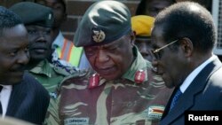FILE - Zimbabwe's President Robert Mugabe, right, talks to General Constantine Chiwenga upon his arrival at Harare International Airport, July 4, 2008.