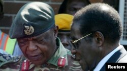 FILE - Zimbabwe's President Robert Mugabe, right, talks to General Constantine Chiwenga upon his arrival at Harare International Airport, July 4, 2008.