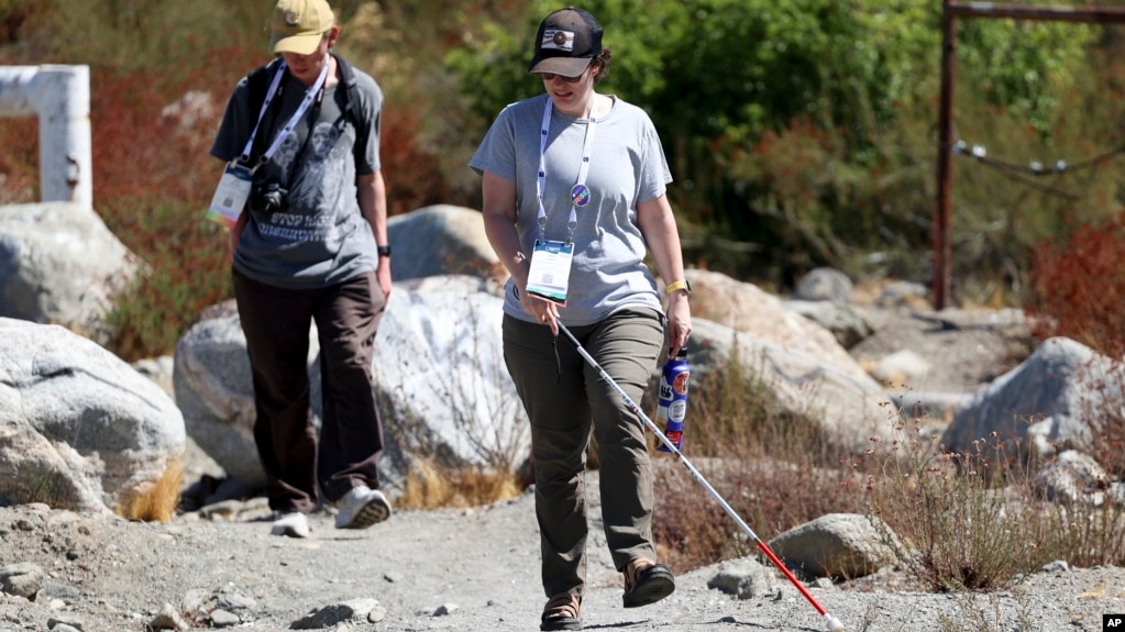 Taormina Lepore, foreground, who has low vision, walks with a white cane during the accessible field trip Sept. 26, 2024, in San Bernadino, Calif. (AP Photo/Ryan Sun)