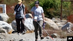 Taormina Lepore, foreground, who has low vision, walks with a white cane during the accessible field trip Sept. 26, 2024, in San Bernadino, Calif. (AP Photo/Ryan Sun)