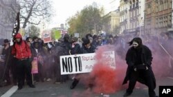 Protesters in London set off a smoke flare as thousands of students across Britain protest against tuition fee hikes, 24 November 2010