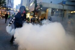 An anti-extradition bill protester throws a tear gas cartridge back at police during clashes in Wan Chai in Hong Kong, Aug. 11, 2019.