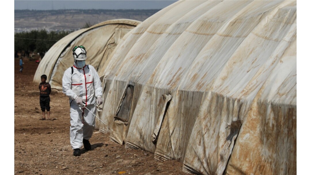 Anggota Pertahanan Sipil Suriah menyemprotkan cairan disinfektan di tenda di kamp Bab Al-Nour untuk mencegah penyebaran virus corona (COVID-19) di Azaz, Suriah, 26 Maret 2020. (Foto: Reuters)