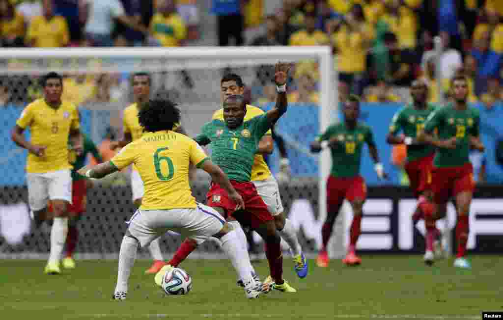 برازیل کے کھلاڑی اور کیمرون کے کھلاڑی فٹ بال کےلیے مدّمقابل