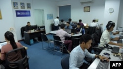 FILE - Cambodian online news outlet 'Fresh News' staff members work in their newsroom in Phnom Penh, May 21, 2018.