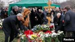 Những người đưa tang, trong đó có ông Mikhail Kasyanov (trái), một nhà lãnh đạo đối lập và cựu Thủ tướng Nga, đặt hoa tại mộ phần của ông Boris Nemtsov trong tang lễ ở Moscow, ngày 3/3/2015.