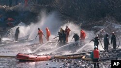 In this April 21, 1989 file photo, crews use high pressured hoses to clean up after the Exxon Valdez oil spill off the coast of Alaska. (AP Photo/Rob Stapleton, File)