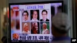 A man watches a TV news program on the reward poster of Yoo Byung-eun at the Seoul Train Station in Seoul, South Korea, May 26, 2014. 