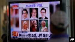 A man watches a TV news program on the reward poster of Yoo Byung-un at the Seoul Train Station in South Korea, May 26, 2014. 