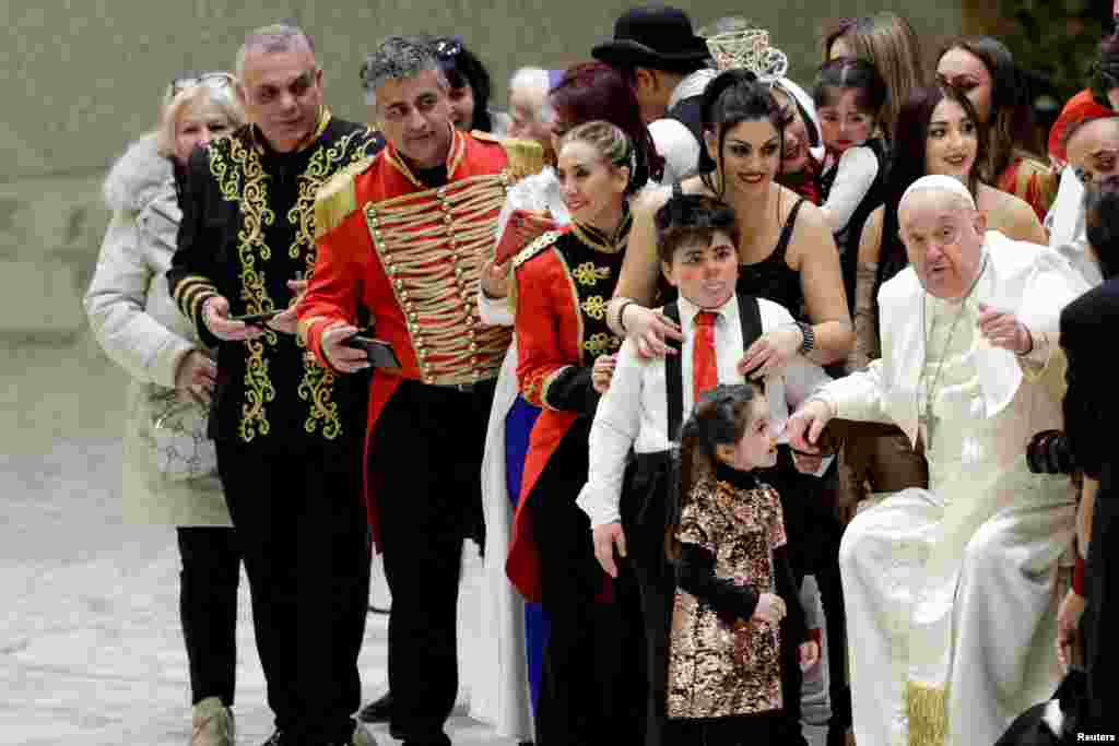 Pope Francis gestures prior to posing for a photo with Roller Circus members at the end of the weekly general audience, in Paul VI hall at the Vatican.