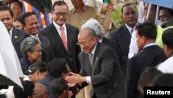 Cambodia's King Norodom Sihamoni (C) greets government officials after returning from China at Phnom Penh International Airport, Sept. 11, 2013. 