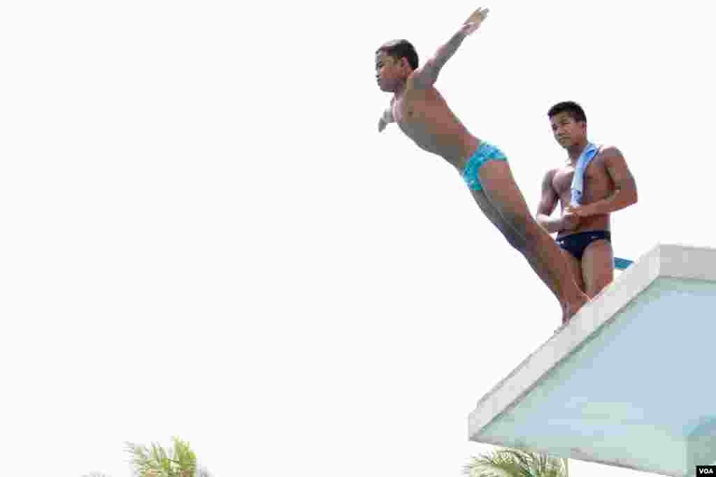 Jordan Pisey Windle​, a Cambodian-born U.S. diving champion, watches on as a young Cambodian prepares to dive into the pool, in Phnom Penh, Cambodia, May 12 2016. (Hean Socheata/ VOA Khmer)