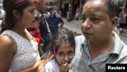 Local residents evacuate onto a street minutes after an earthquake in central Kathmandu, Nepal, May 12, 2015. 