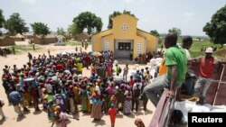 FILE - People queue for food aid distribution delivered by the United Nations Office for the Coordination of Humanitarian Affairs and world food program in the village of Makunzi Wali, Central African Republic, April 27, 2017.