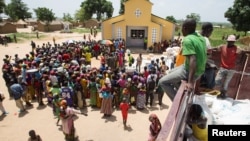 FILE - People queue for food aid distribution delivered by the United Nations Office for the Coordination of Humanitarian Affairs and world food program in the village of Makunzi Wali, Central African Republic, April 27, 2017.