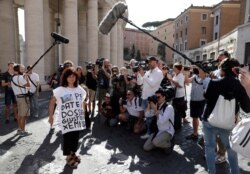 A demonstrator wears a shirt with writing in Italian reading "Please give the justice dossier for Emanuela" on the outskirts of the Vatican, in Rome, Thursday, July 11, 2019.