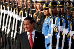 FILE - Myanmar's President Win Myint reviews the honor guard during his welcome ceremony at the Government House in Bangkok
