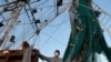 Minh Nguyen, wearing a mask out of fear of the catching the coronavirus, cleans his shrimp boat in Morgan City, La. Monday, May 11, 2020. 