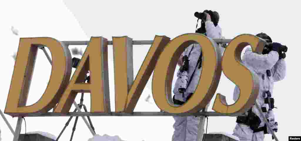 Swiss special police officers observe the surrounding area from atop the roof of the Davos Congress Hotel in the Swiss mountain resort of Davos. More than 1,500 business leaders and 40 heads of state or government will attend the Jan. 21-24 meeting of the World Economic Forum (WEF) to network and discuss big themes, from the price of oil to the future of the Internet.